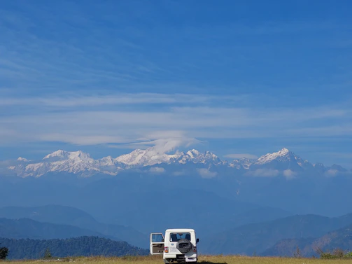 A spacious white SUV parked in front of a mountain lodge, perfect for adventure seekers.