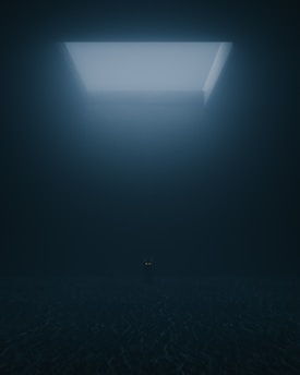 a dark room with a light coming from the ceiling