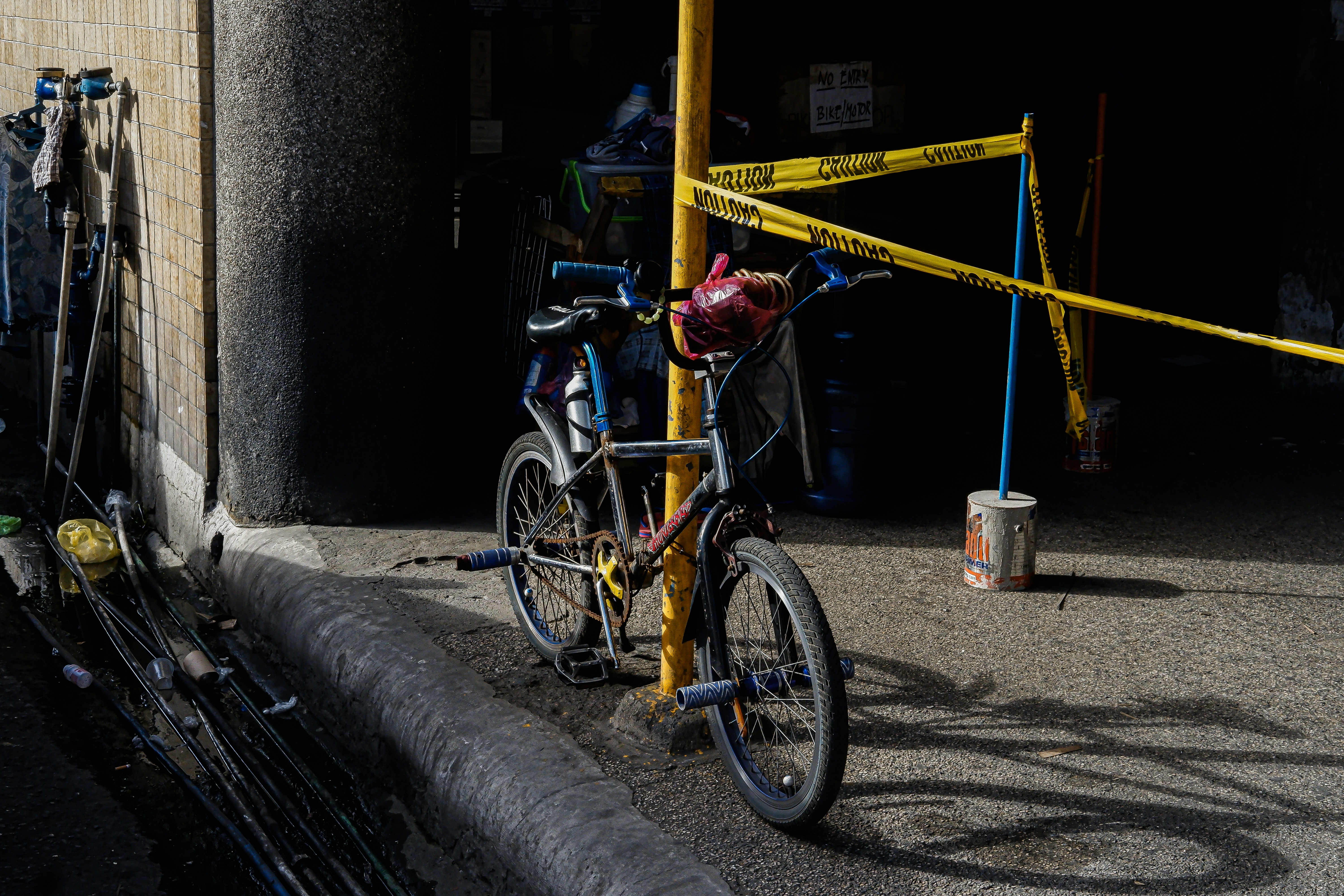 a bicycle parked next to a yellow caution pole