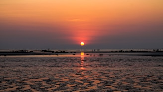 the sun is setting over a body of water