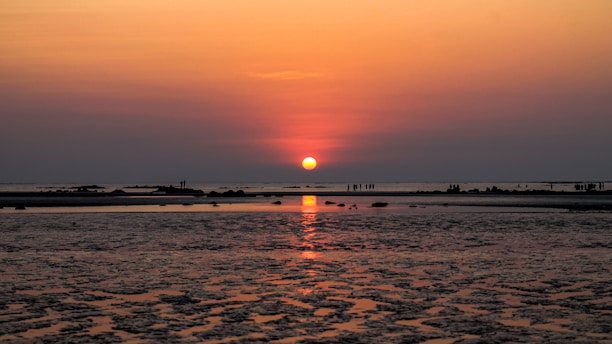 the sun is setting over a body of water