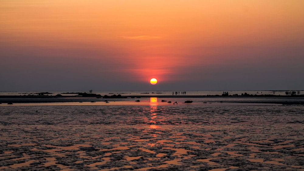 the sun is setting over a body of water