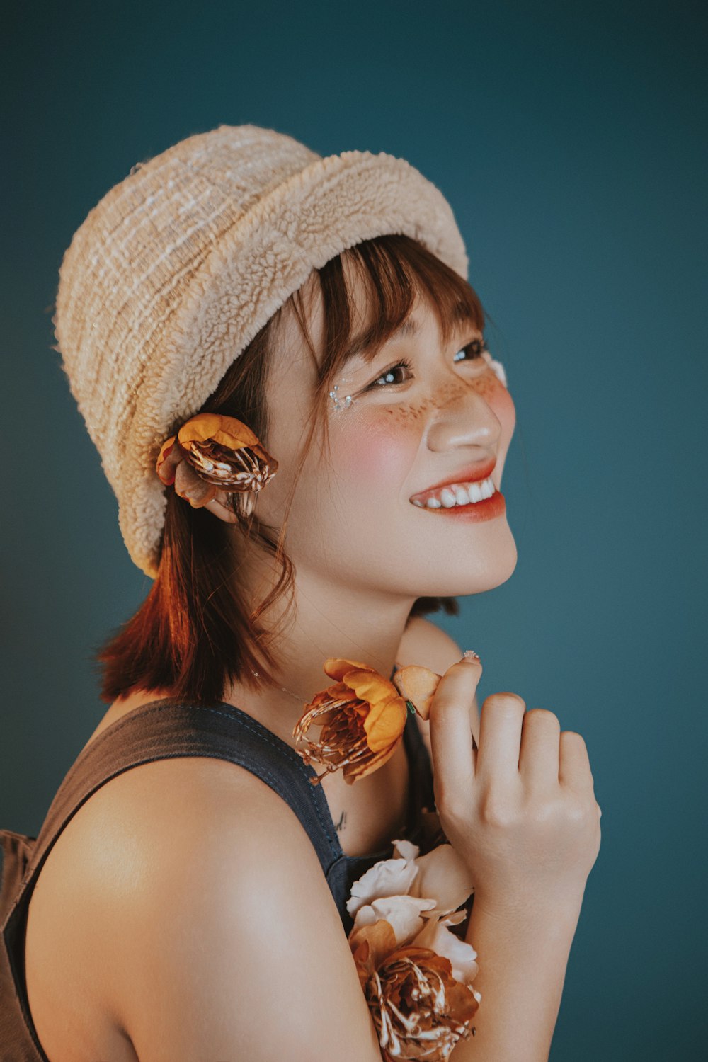 a woman wearing a hat and holding a banana