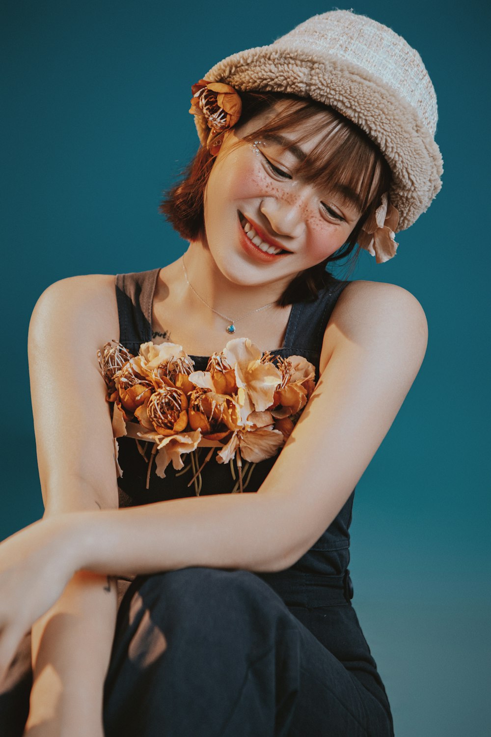 a woman sitting on the ground with a hat on her head