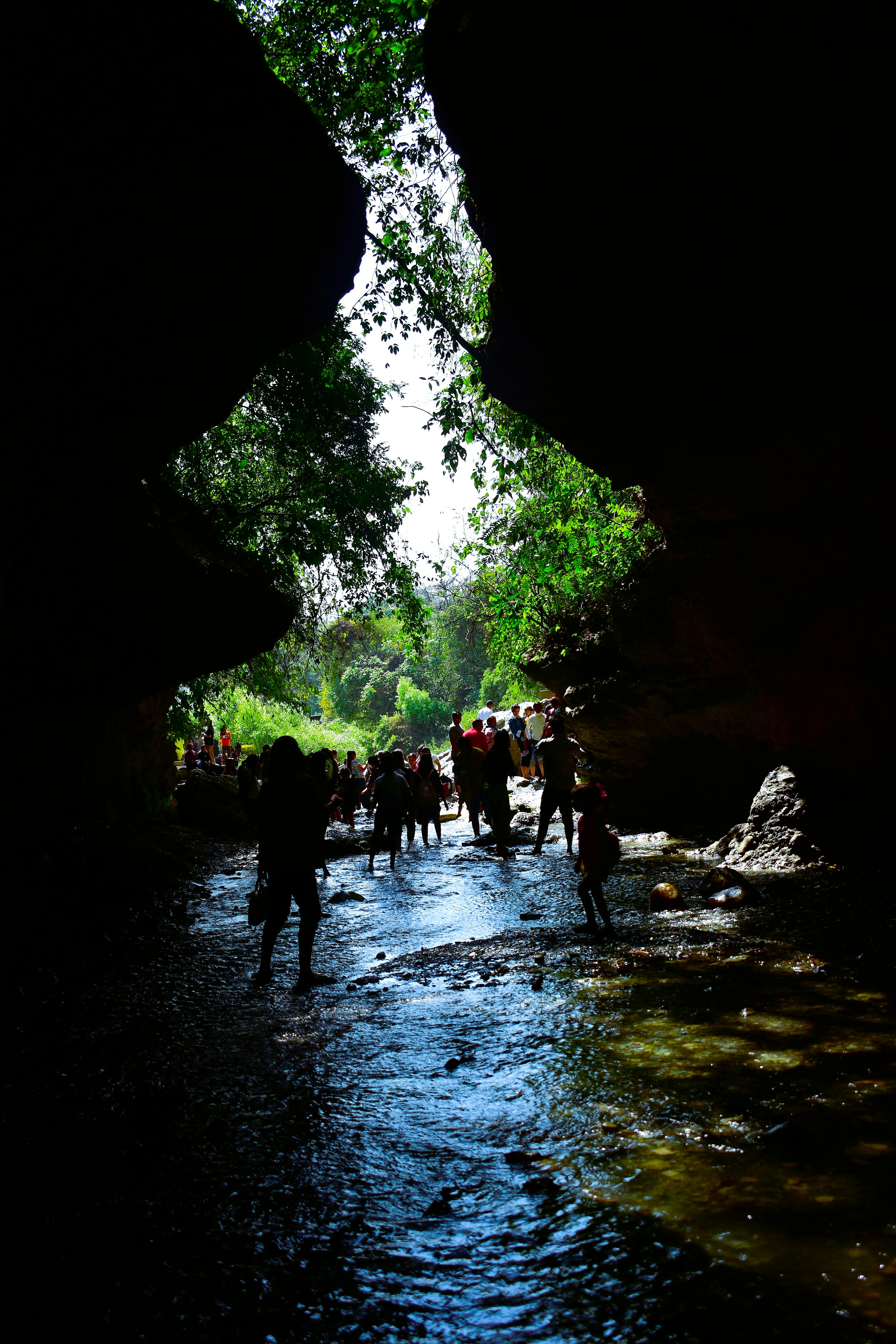 a group of people walking through a cave