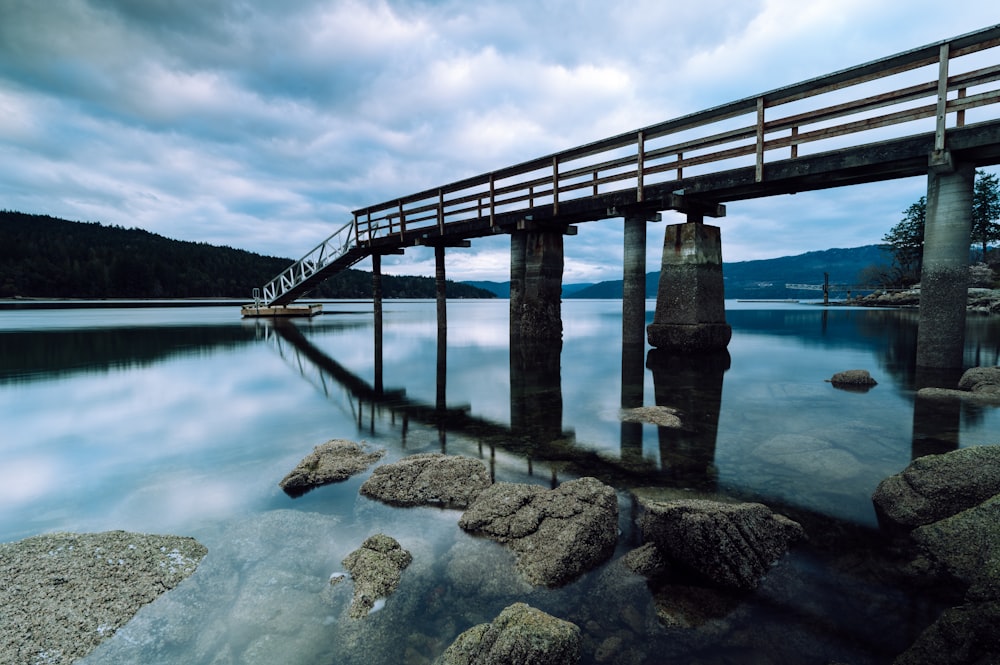 a bridge over a body of water under a cloudy sky