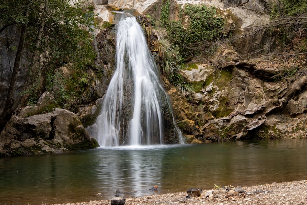 a small waterfall in the middle of a forest