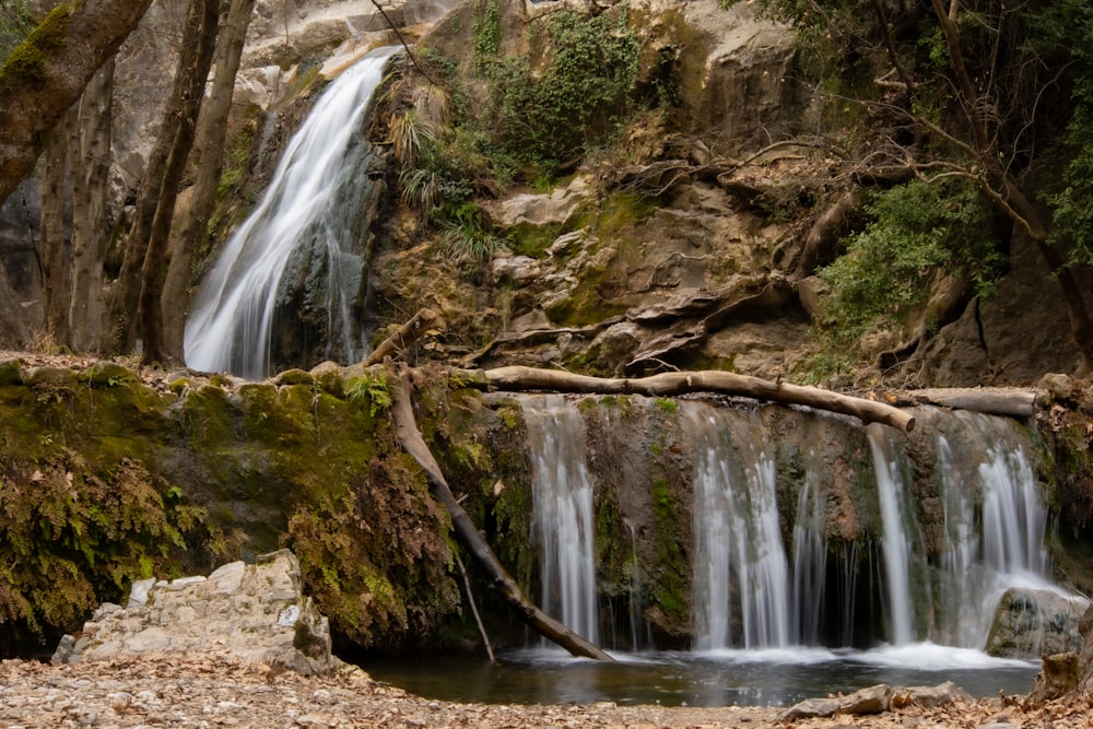 a small waterfall in the middle of a forest