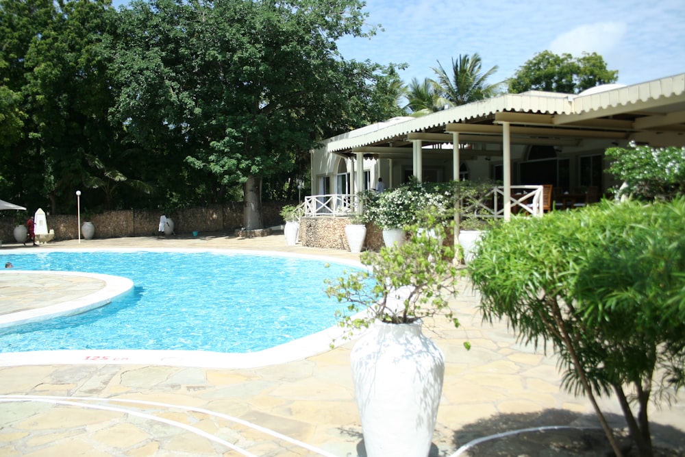 a swimming pool with a large white vase in front of it