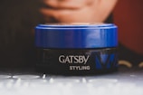 Close-up of a male influencer showcasing a matte finish hair styling product with sharp branding.