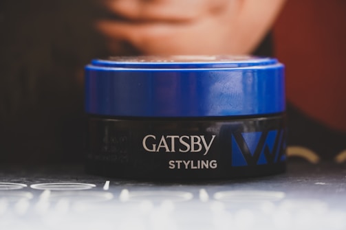 Close-up of a male influencer showcasing a matte finish hair styling product with sharp branding.