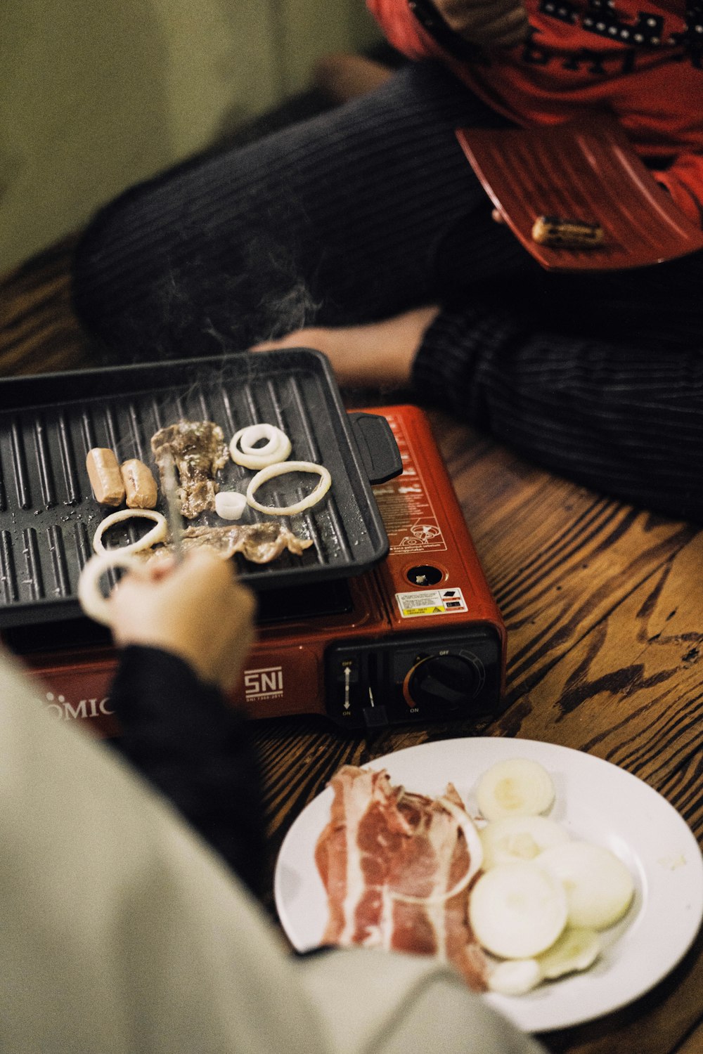 a person sitting on the floor next to a plate of food