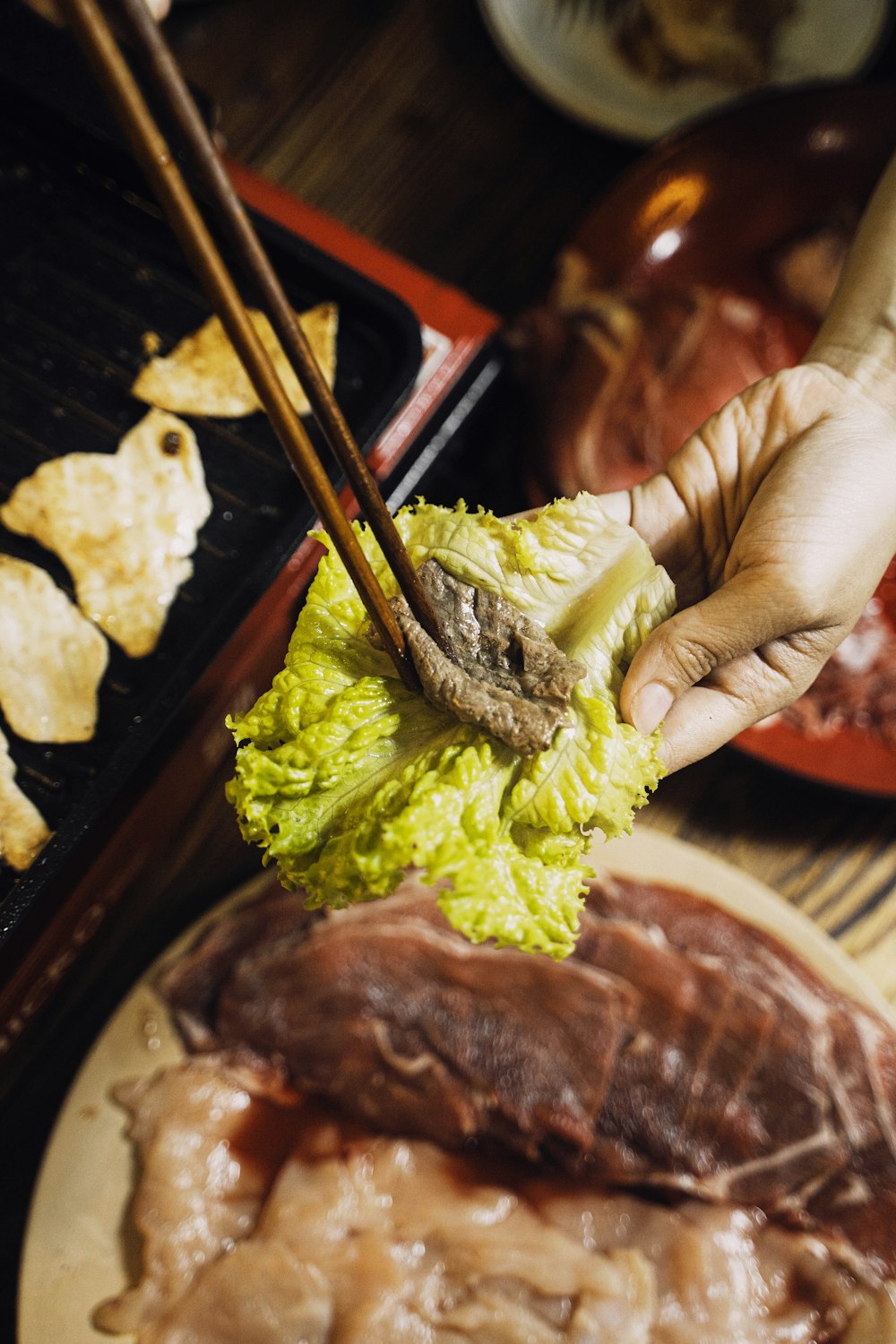 a person holding chopsticks over a plate of food