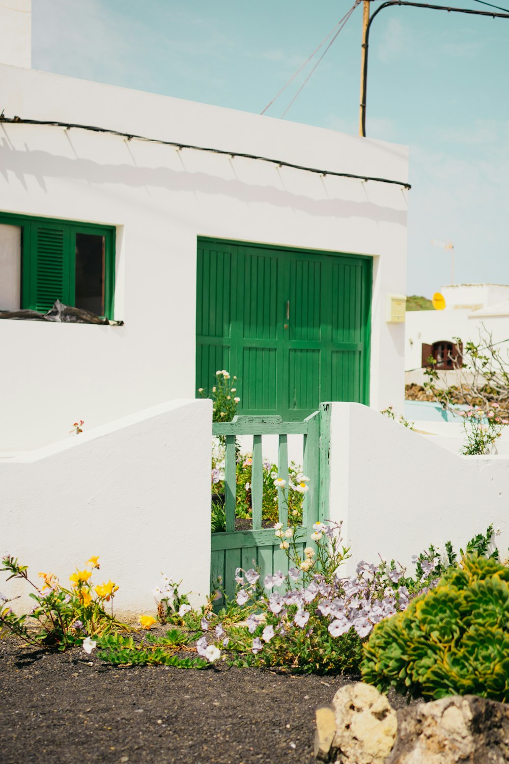 a white house with a green door and green shutters