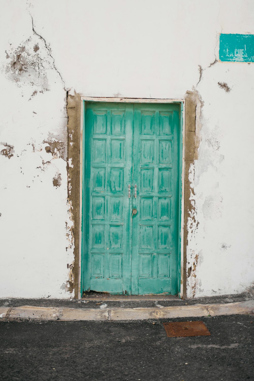 a green door on the side of a white building