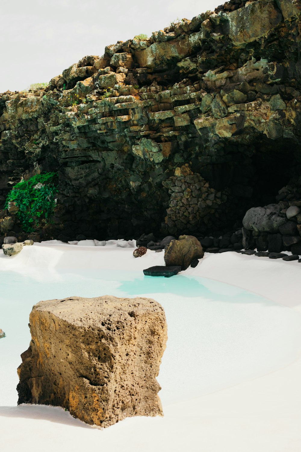 a large rock sitting in the middle of a pool of water