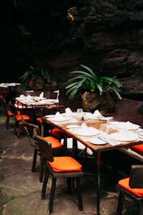 a table set up for a meal with orange chairs