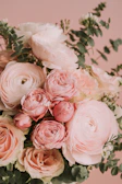 Soft pastel bouquet with peach and nude roses arranged delicately on a cream linen background.