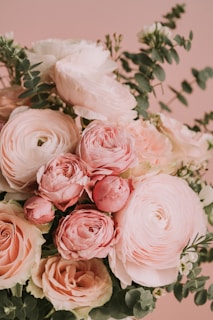 A delicate bouquet of roses and lilies on a soft pink background symbolizing heartfelt messages.