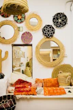 A collection of woven decorative baskets filled with vibrant throws and pillows.