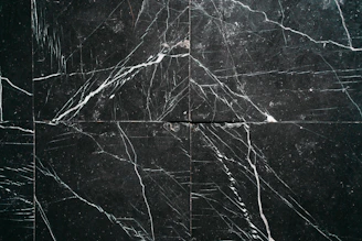 a black marble tile with white lines on it