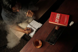 a man sitting at a table smoking a cigarette