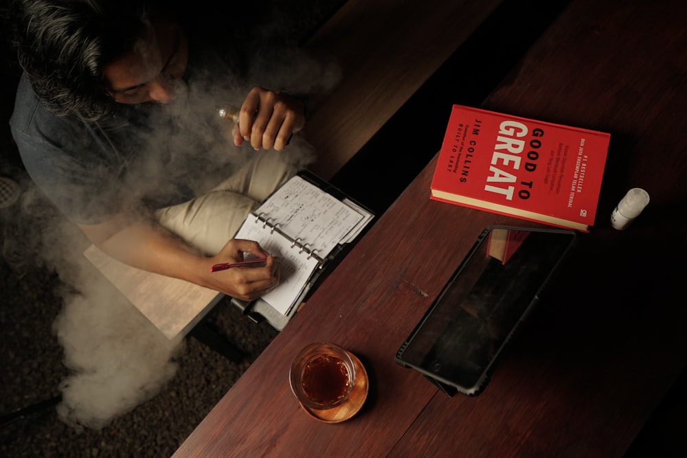 a man sitting at a table smoking a cigarette