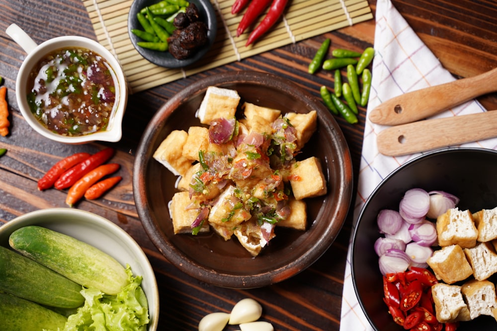 a wooden table topped with bowls of food