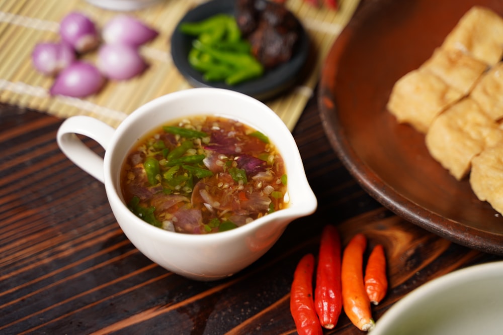 a bowl of soup next to a plate of food