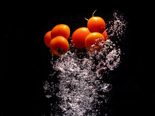 a group of tomatoes splashing into the water