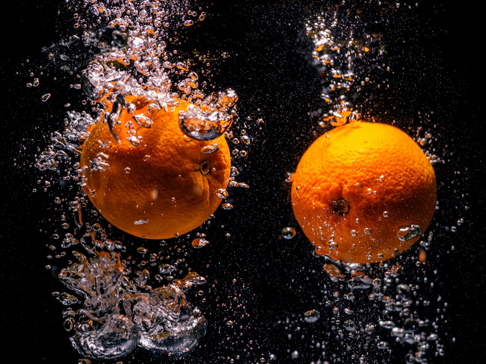 a couple of oranges that are in the water