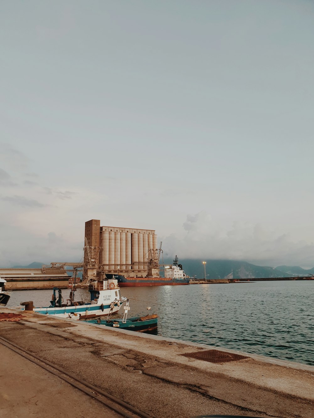 a body of water next to a dock with boats