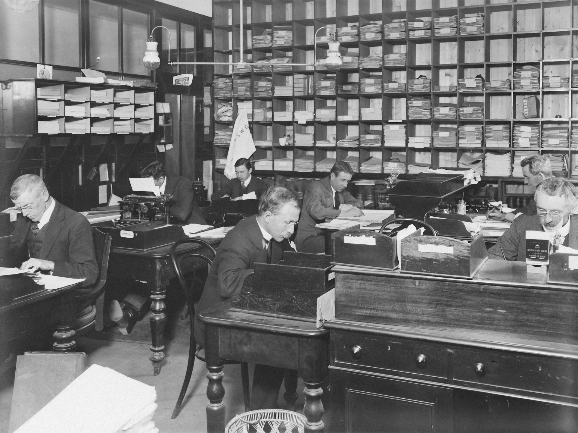 a black and white photo of people in a library