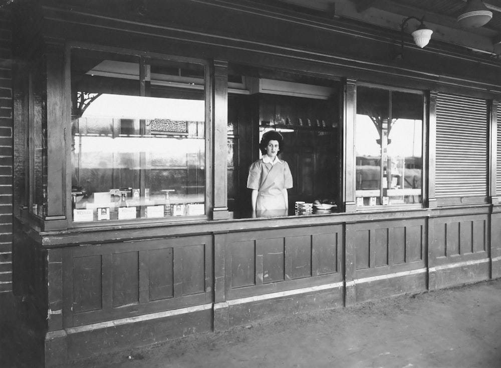 a woman standing in a window of a store