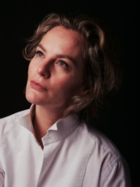 a woman in a white shirt looking off into the distance