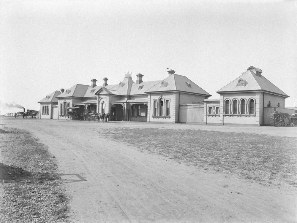 a black and white photo of a horse and buggy in front of a building