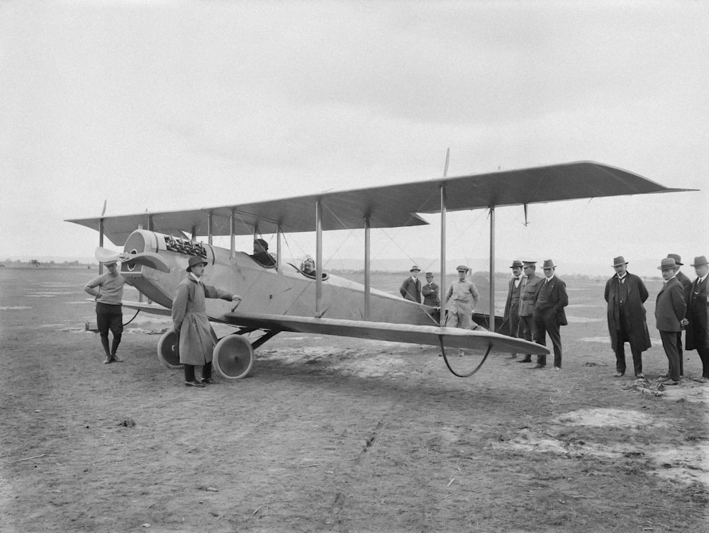 a group of people standing around a small airplane