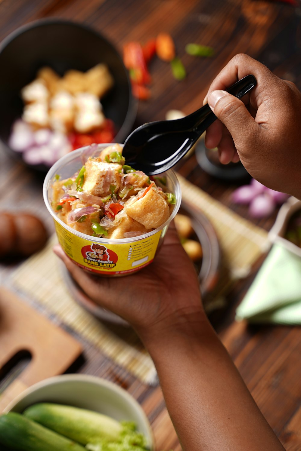 a person holding a spoon over a bowl of food