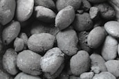 Stacks of premium charcoal briquettes ready for export with a charcoal grey background.