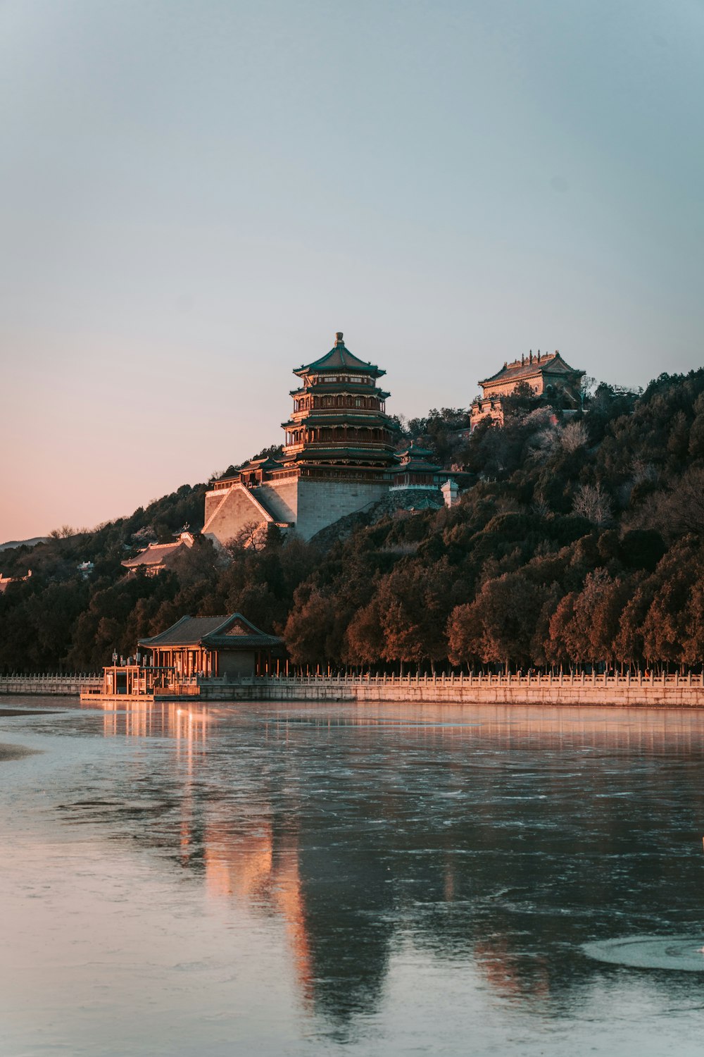 a large body of water with a building on a hill in the background