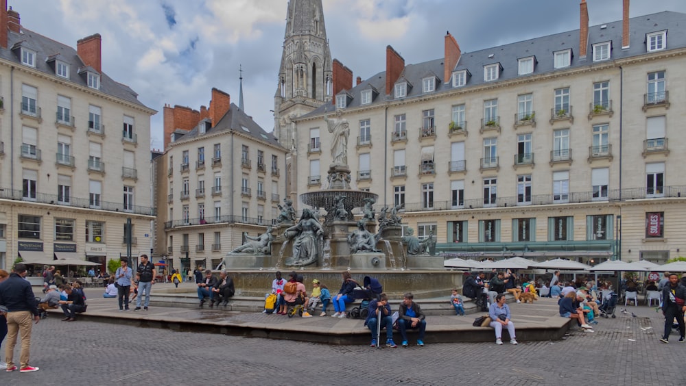 a group of people standing around a fountain