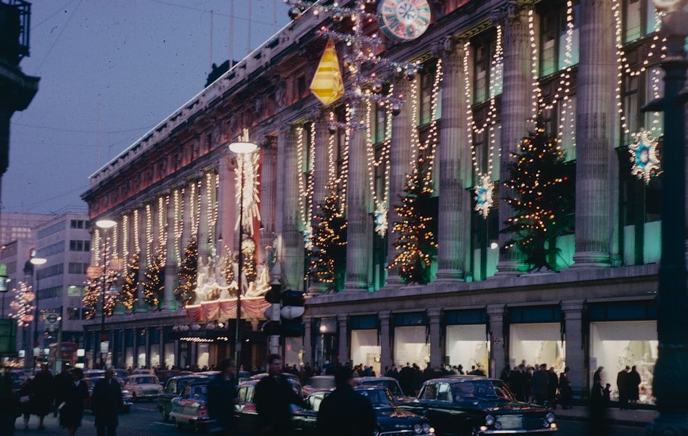 a busy city street with christmas lights on the buildings