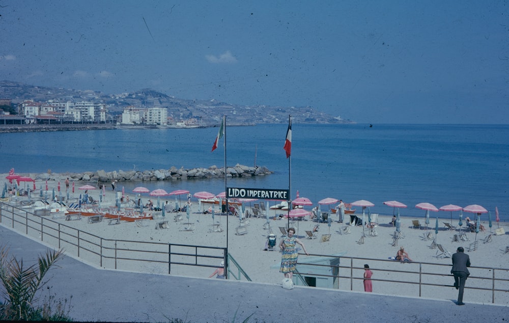 a crowded beach with people and umbrellas on a sunny day