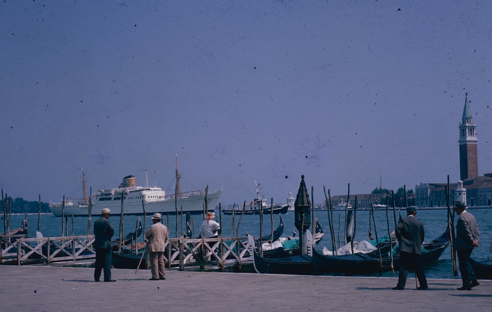 a group of people standing next to a body of water