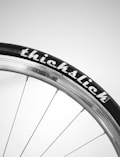A close-up view of a bicycle wheel with the tire branded as 'thickslick'. The rim is metallic with spokes extending to the hub.