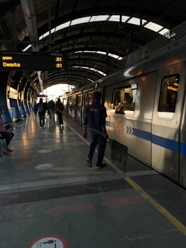 Valet staff assisting a commuter at a busy Delhi Metro parking entrance.