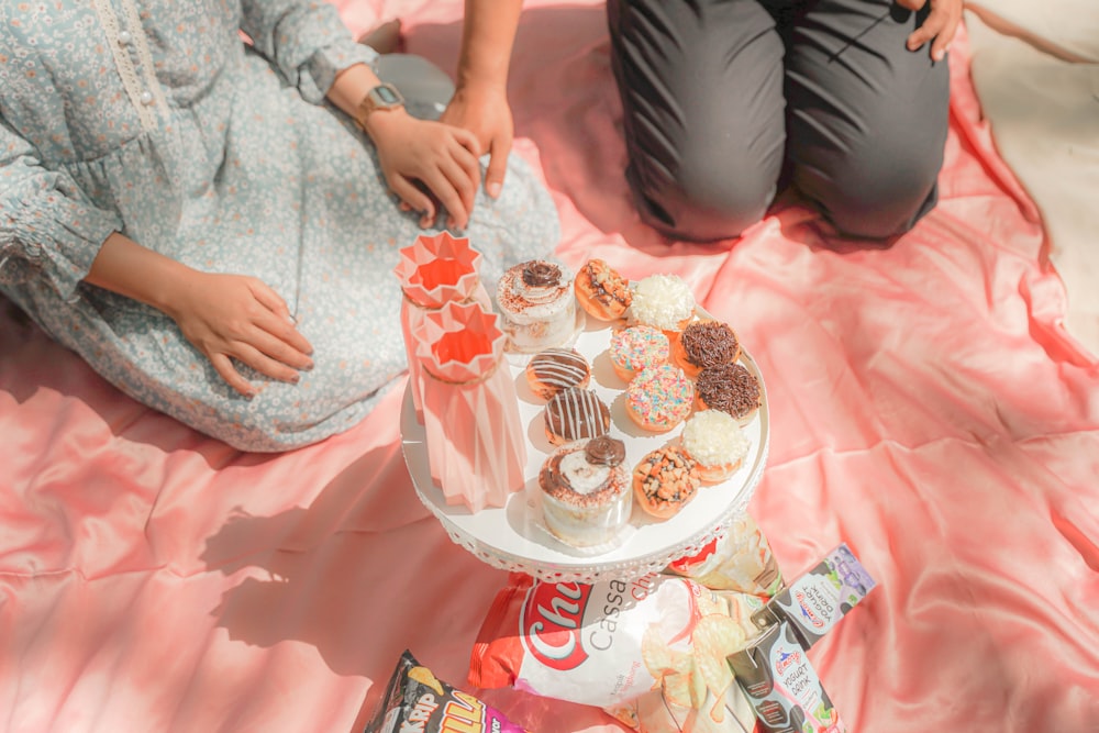 a couple of people sitting on a bed with a cake