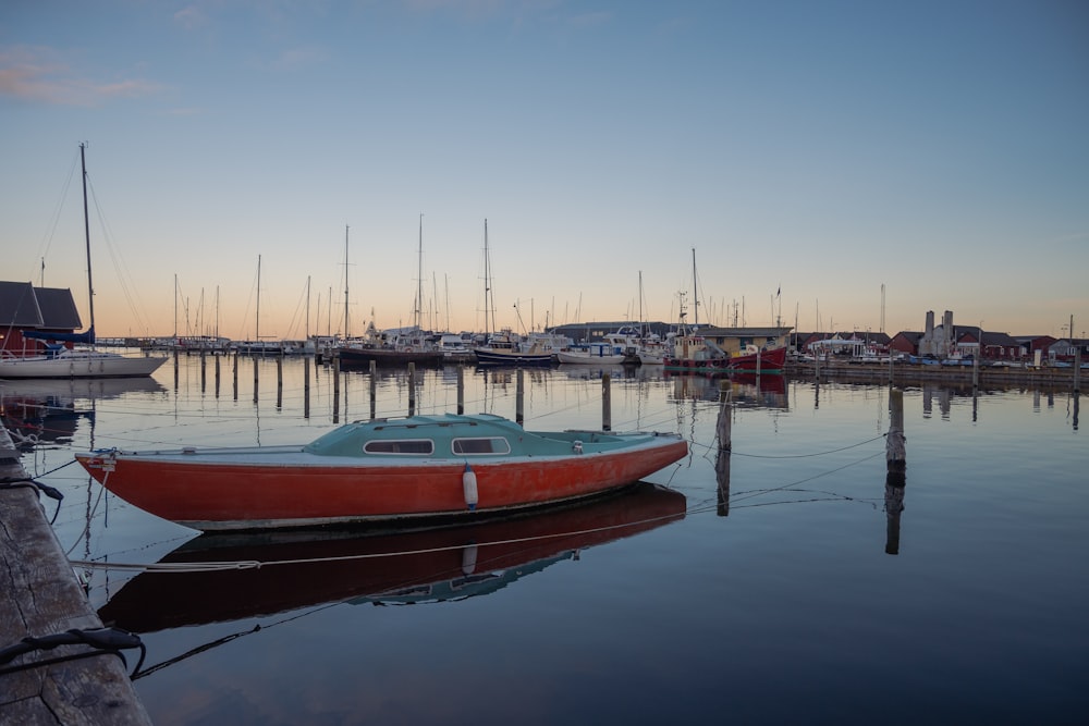 a small boat sits in the water near a dock