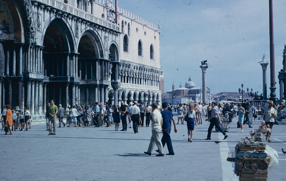 a crowd of people walking around a city square