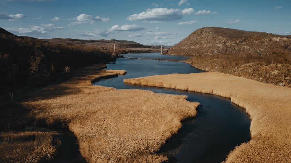 a body of water surrounded by brown grass